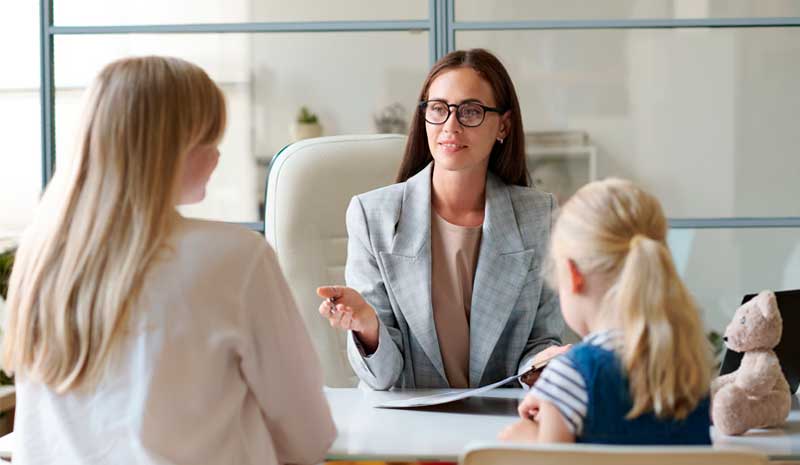 Psicóloga realizando assistência técnica em litígios familiares com mãe e criança em consultório - Valente Perícias
