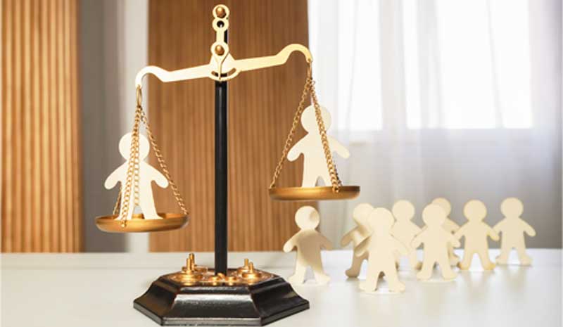 Prova técnica em disputas judiciais representada pela balança da justiça e figuras humanas, simbolizando equilíbrio, proteção de direitos e análise imparcial, conforme atuação da Valente Perícias.