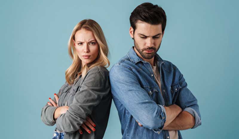 Casal de braços cruzados, de costas um para o outro, olhando para a câmera com expressão de raiva, representando conflito conjugal em contexto de separação | Valente Perícias